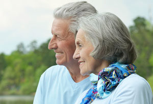 Elderly couple smiling at something off camera.