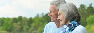 Elderly couple looking at something and smiling.