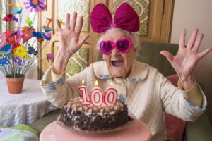 funny humorous woman turning 100 years old celebrating with birthday cake