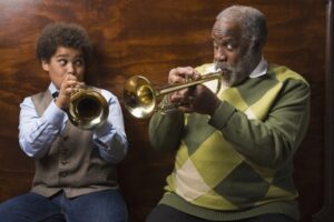 Grandfather playing trumpet with grandson