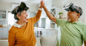 Senior, couple and home with virtual reality for games in living room, cheerful and bonding. House, couch and entertainment for fun with vr headset to relax, fun and retirement with technology.